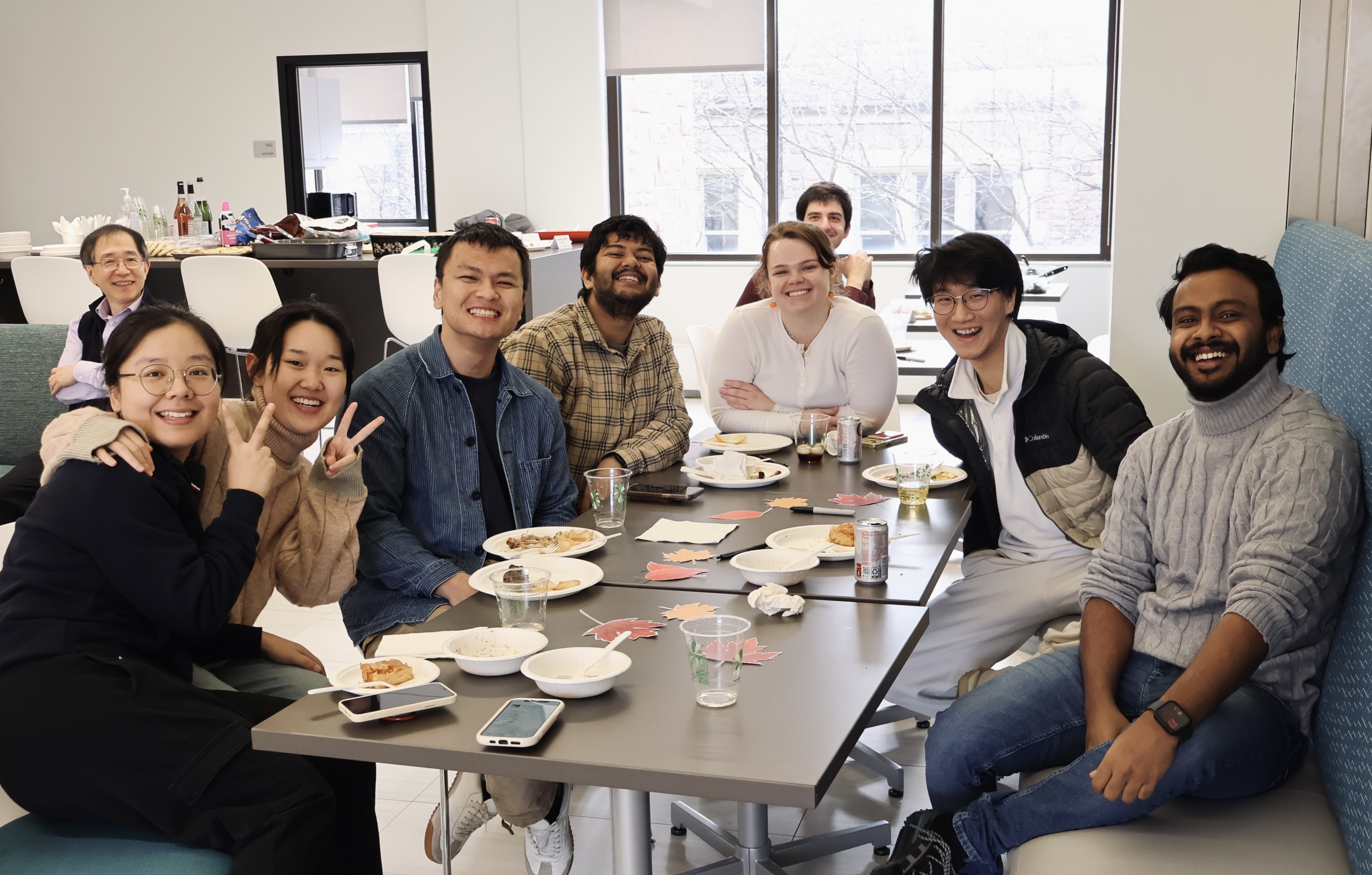 Nine people from the SDS department smile at the camera, surrounded by food