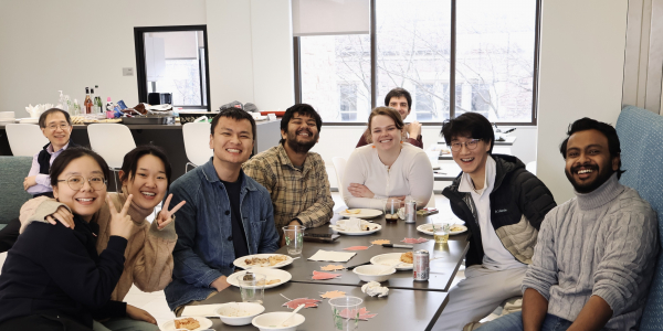 Nine people from the SDS department smile at the camera, surrounded by food