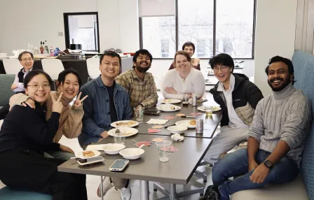 Nine people from the SDS department smile at the camera, surrounded by food