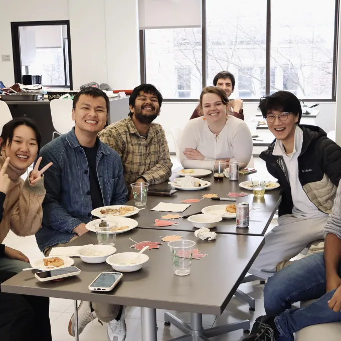Nine people from the SDS department smile at the camera, surrounded by food